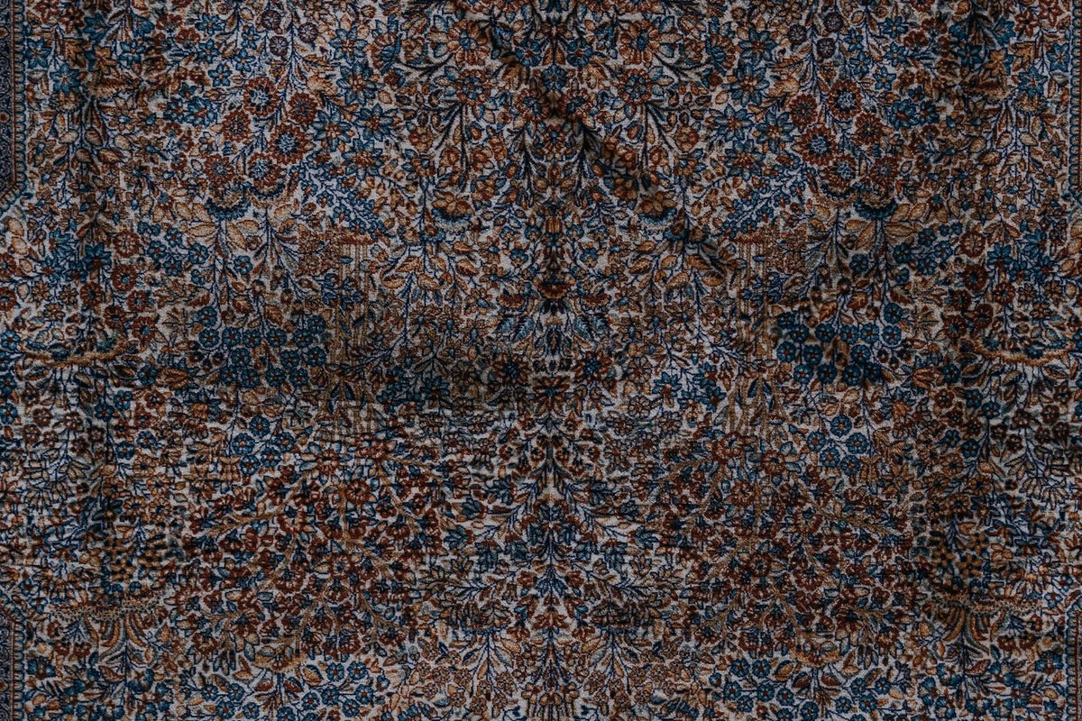 Gros plan sur les motifs floraux et géométriques d'un tapis persan