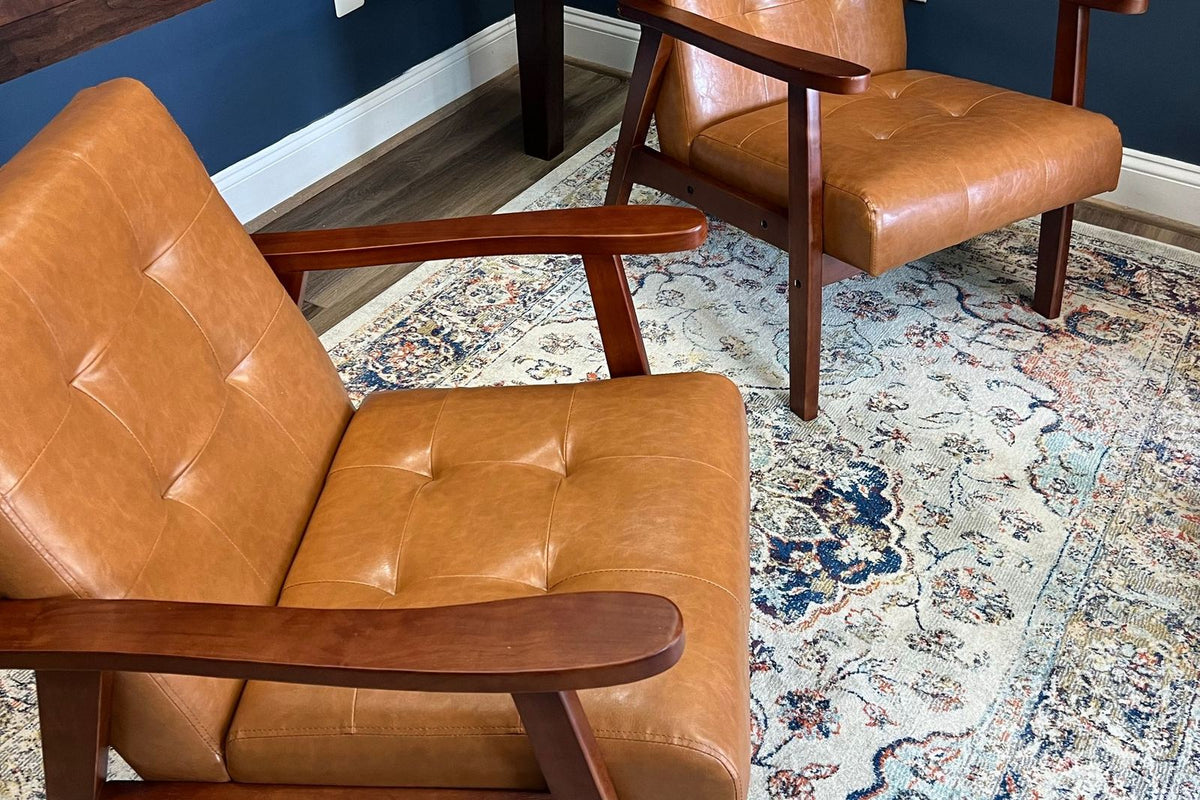 Deux fauteuils en cuir posés sur un tapis à motif persan dans un salon